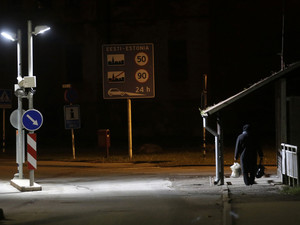 A woman walks past a border crossing point with Estonia in Valka