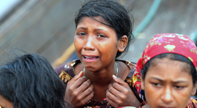 An emotional Rohingya Muslim woman, fleeing sectarian violence in Myanmar, is pictured on an intercepted boat trying to cross the Naf river into Bangladesh in Teknaf on June 13, 2012. 
